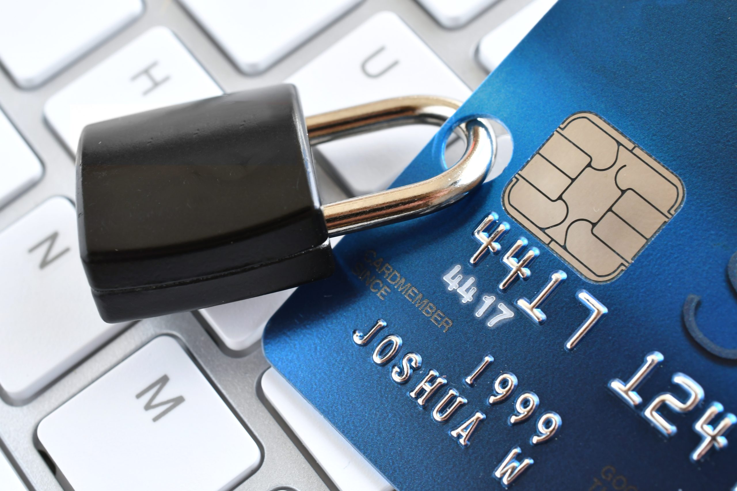 A credit card with a padlock on top of a keyboard.