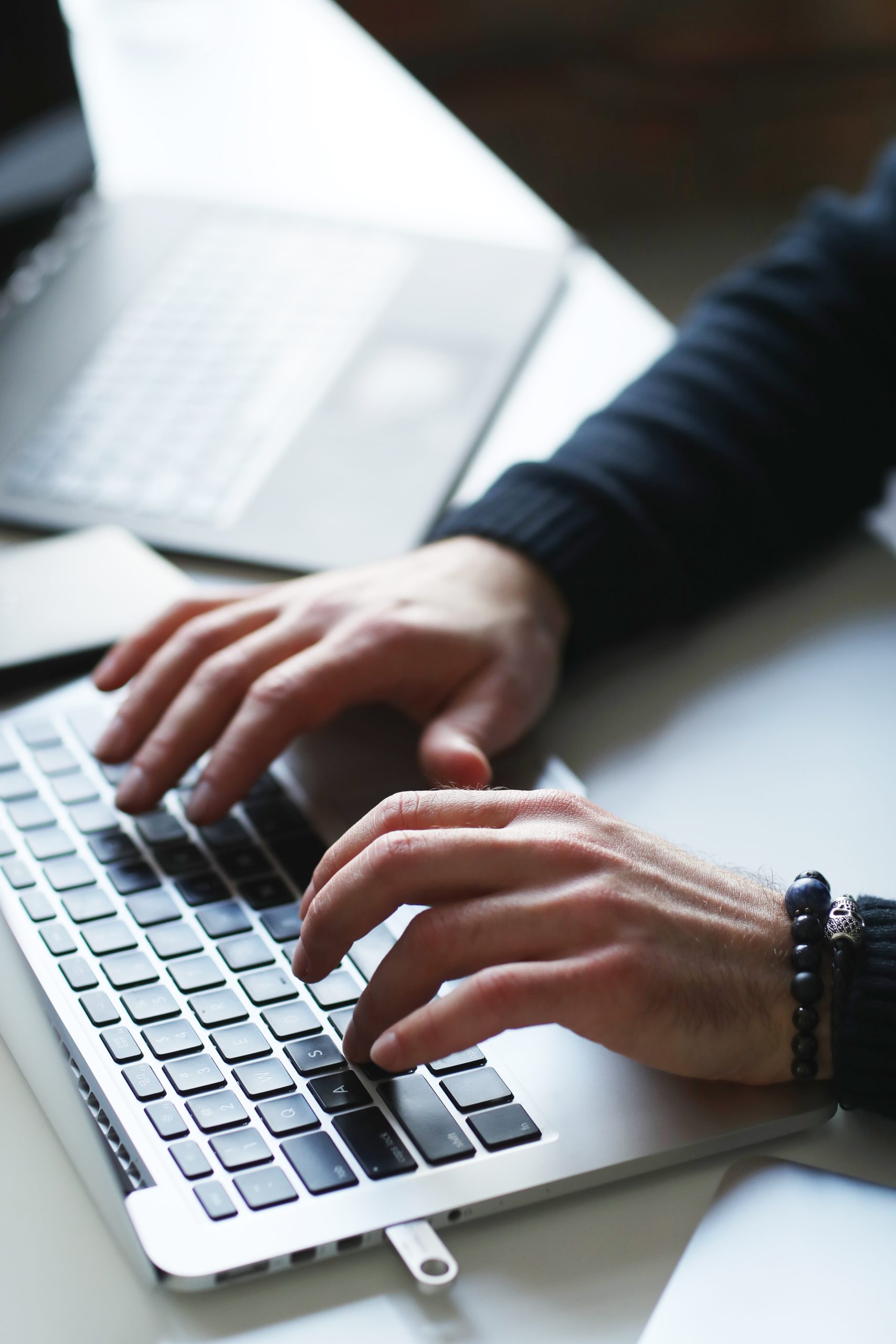 A person typing on a laptop keyboard.