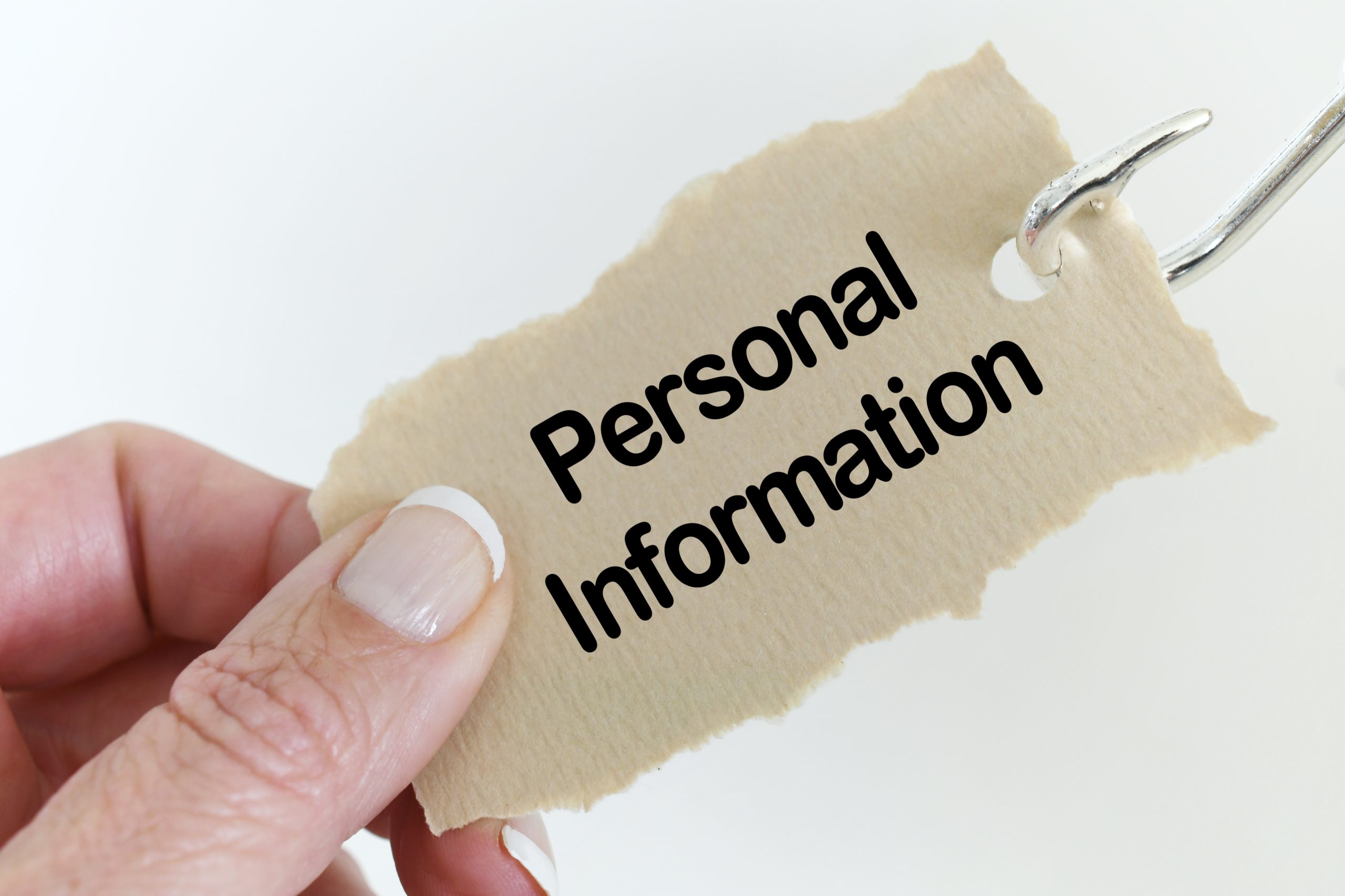 A person holding a piece of paper with the word personal information.