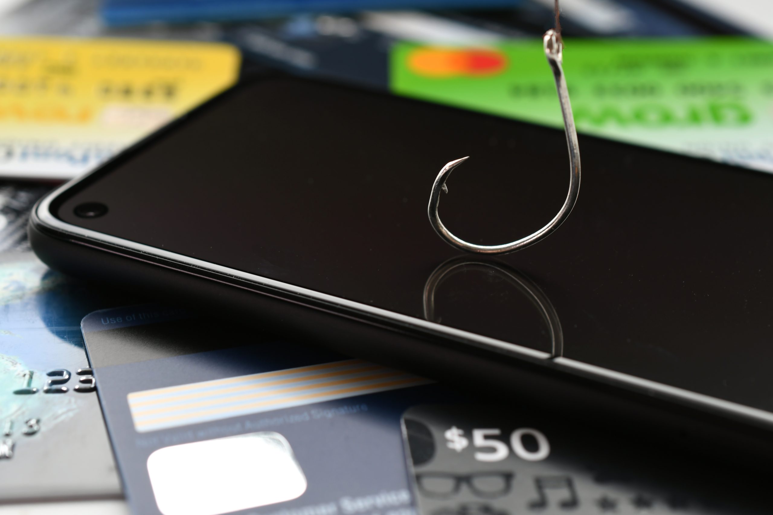 A cell phone with a fishing hook attached to it.