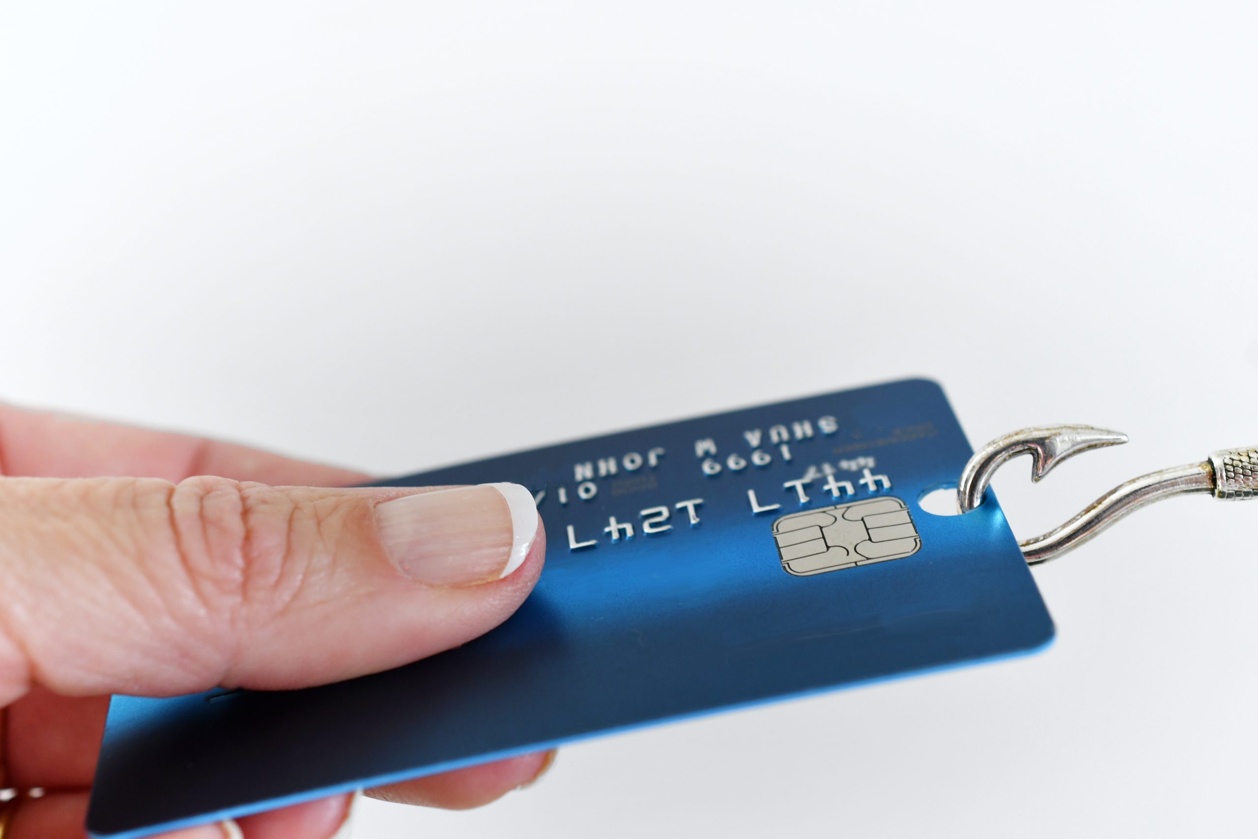 A person holding a credit card with a hook.