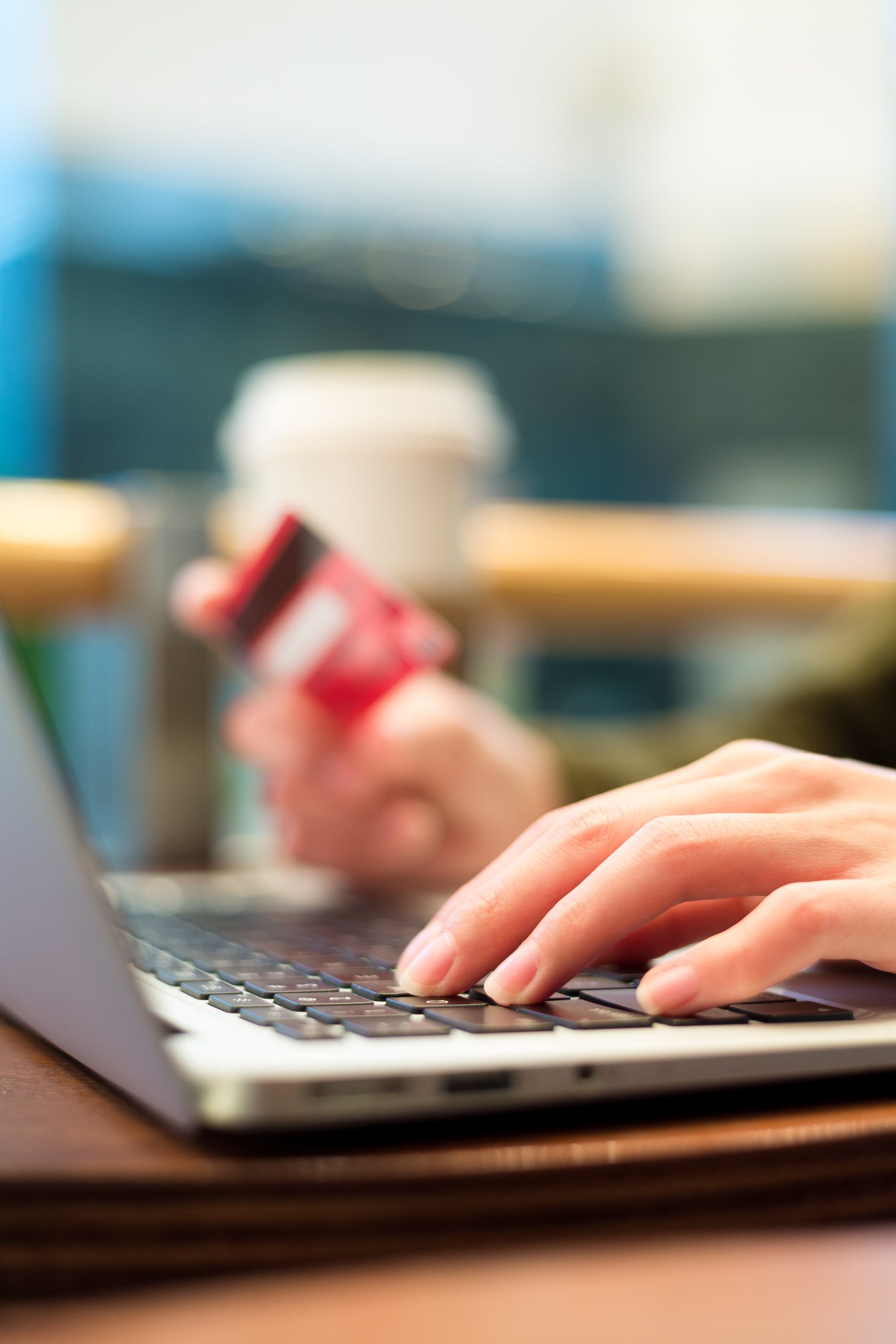 A woman is using a laptop with a credit card.